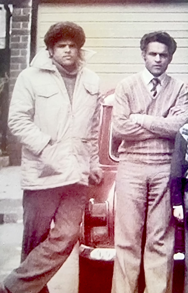 A coloured photograph of two British Asian men leant against a car, taken in the 1970s. Photograph: Mohammed Ashraf