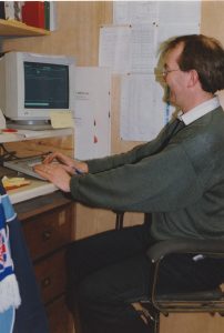 A coloured photograph of a male office worker at a computer for E&S Smiths. Photograph: Richard Smith